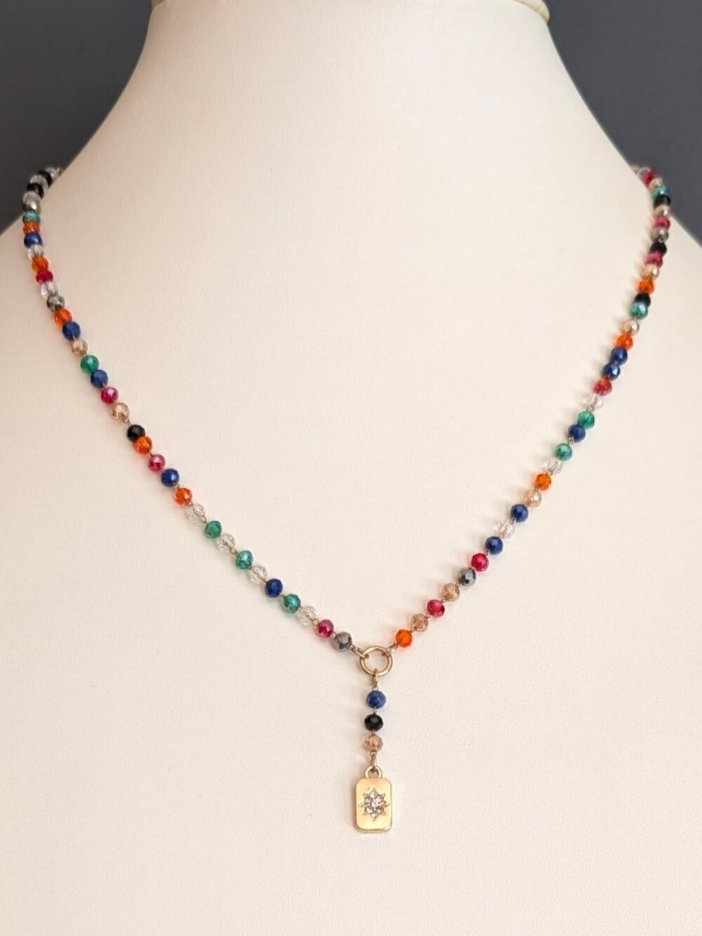 Tiny multi colored crystal necklace with gold tone pendant and clear crystals